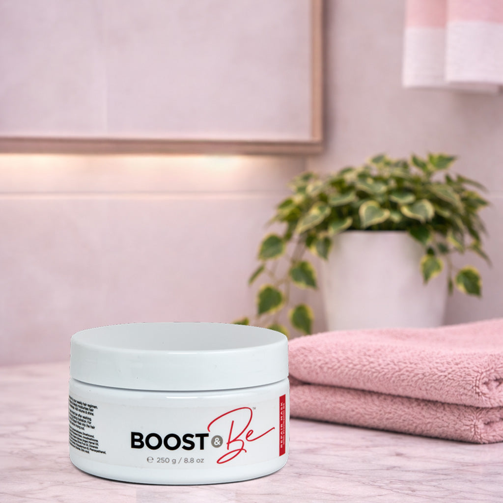 Boost & Be ten minute repair hair mask on a wooden surface with a plant and towel in the background.