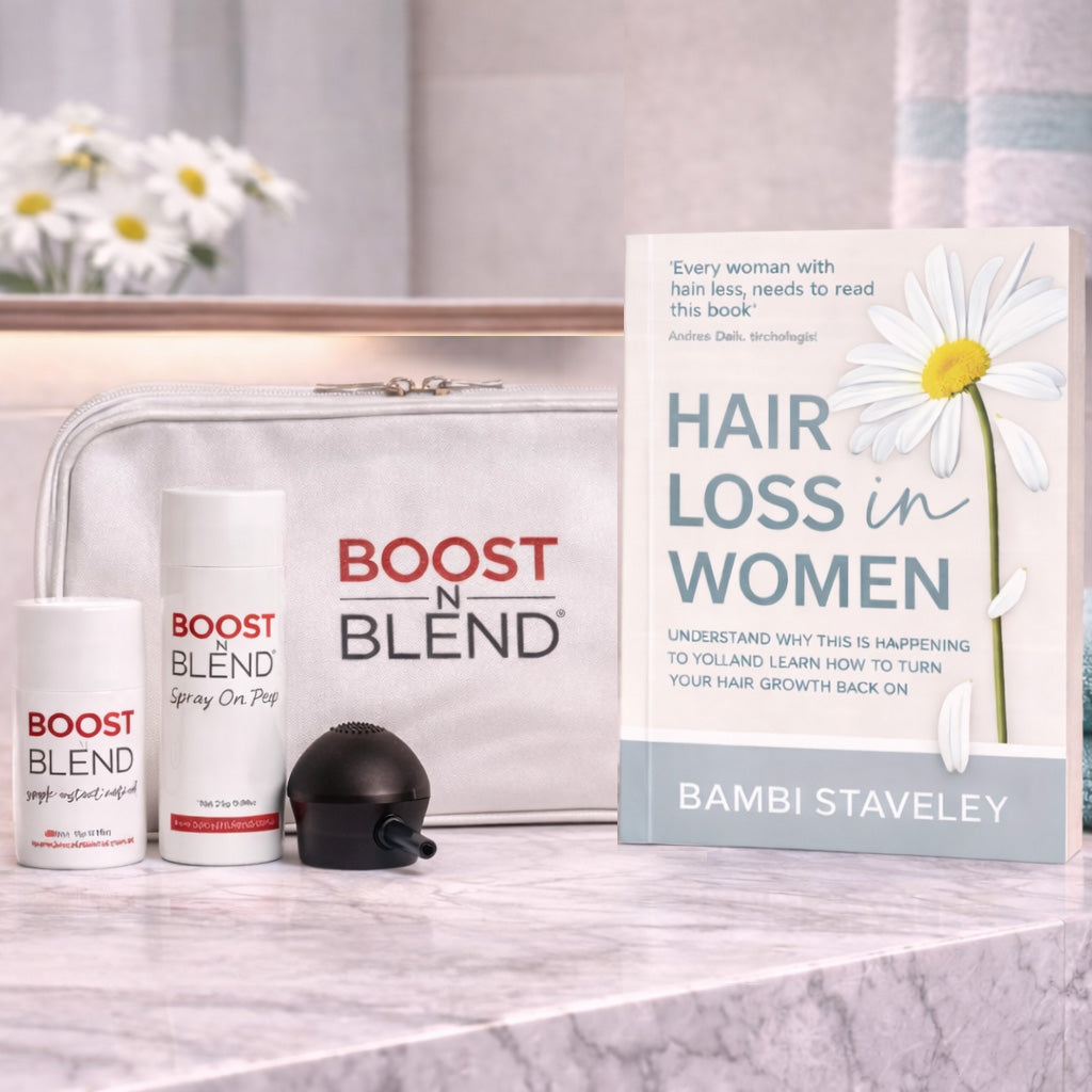 Boost N Blend hair loss products and a book titled 'Hair Loss in Women' by Bambi Staveley on a marble surface.